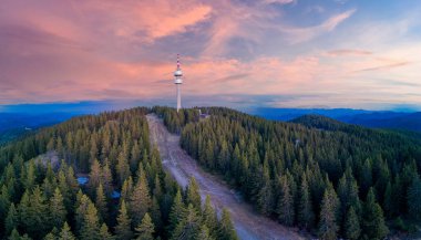 Yüksek telekomünikasyon ünlü Snezhanka kulesi Rodop dağları vadisinde ve kasvetli bir gökyüzüne karşı ormanlar. Panorama, üst manzara