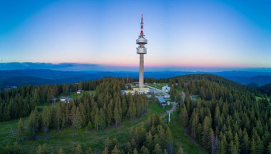 Yüksek telekomünikasyon ünlü Snezhanka kulesi Rodop dağları vadisinde ve kasvetli bir gökyüzüne karşı ormanlar. Panorama, üst manzara