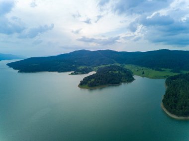 Dağlar arası mavi gölde yuvarlak ağlı tatlı su balıklarının profesyonel üretimi. Bulutlu hava, Rodop dağları, Avrupa