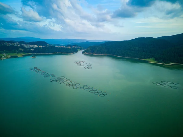 stock image Professional breeding of freshwater fish in intermountain blue lake with round nets. Cloudy weather, Rhodope mountains, Europe