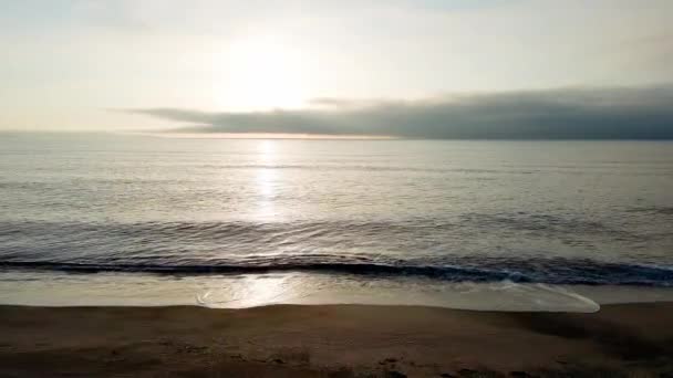 白い雲と明るい夜明けの太陽と曇りの色の空に対して 近くの光と砂の野生の空のビーチを反映冷たい水で穏やかな青の無限の黒海 Uhd 4Kビデオリアルタイム — ストック動画