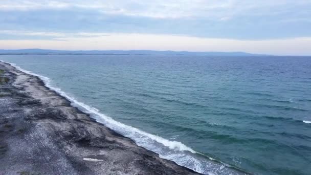 深沉平静的波涛汹涌的黑海 充满泡沫的海浪 碧绿透明的清澈海水 在多云的灰色天空下 用沙粒的黑色沙粒冲刷着荒芜的海岸 Uhd 4K视频实时处理 — 图库视频影像