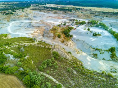 Large wild sand craters in nature of vegetative Montenegro and modern equipment and machines for the extraction of pure white natural sand against the backdrop of the high mountains of Montenegro