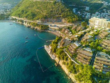 Luxury resort hotel Dukley with chic comfortable apartments, green gardens and sandy beaches near the azure shallow calm Adriatic Sea against the backdrop of the coastal cities of Budva and Becici