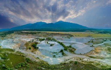 Panorama of large sand craters in nature of vegetative Montenegro and modern equipment and machines for the extraction of pure white sand against the backdrop of the high mountains of Montenegro
