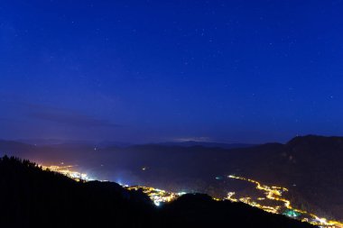 Night intermountain city of Smolyan with bright evening electric lights under a clear sky with bright small stars