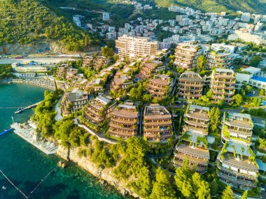 Luxury resort hotel Dukley with chic comfortable apartments, green gardens and sandy beaches near the azure shallow calm Adriatic Sea against the backdrop of the coastal cities of Budva and Becici