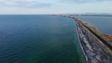 Kuşlar, kumsalın kuru kumla kaplı dar ve sessiz sahil manzarası ve Karadeniz 'in turkuaz körfezi ve akşam güneşinde açık mavi gökyüzünün altında küçük göl taşlarıyla yıkanmış taşlar. UHD 4K video gerçek zamanlı