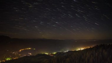 Night intermountain city of Smolyan with bright evening electric lights under a clear sky with bright small stars. UHD 4K video timelaps