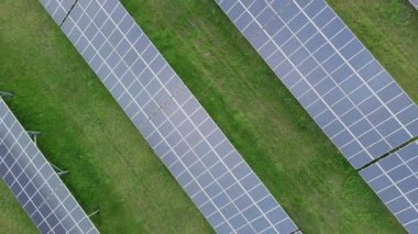 Modern eco-friendly large solar panels to generate energy from suns rays are installed in endless meadows with green grass, under a clear blue sky with bright warm spring sun. UHD 4K video realtime