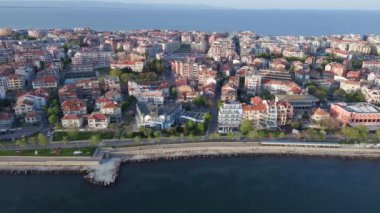 Bulgaristan 'ın kayalık yarımadasında bulunan ve büyük mavi, tuzlu Karadeniz tarafından turlanan küçük ve yoğun nüfuslu Pomorie kasabasına kuş bakışı bir bakış. UHD 4K video gerçek zamanlı