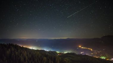 Night intermountain city of Smolyan with bright evening electric lights under a clear sky with bright small stars. UHD 8K video timelaps
