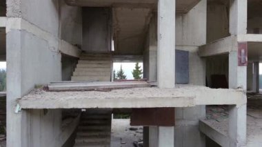 Rodop Dağları 'nın dağ ormanlarındaki vahşi vadisinde otoyol boyunca uzanan çok katlı ve bitmemiş büyük bir bina. UHD 4K video gerçek zamanlı