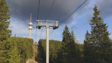 Bottom view of a non-working empty mountain lift and a high tourist tower Snezhanka on the top of one of the Rhodope mountains in cloudy weather. UHD 4K video timelaps