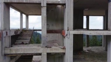 Rodop Dağları 'nın dağ ormanlarındaki vahşi vadisinde otoyol boyunca uzanan çok katlı ve bitmemiş büyük bir bina. UHD 4K video gerçek zamanlı