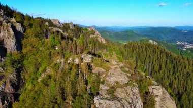 View from high rock to old village town Smolyan with green meadows for cattle walking and houses, between mountain range of Rhodope Mountains sheltered by spruce forests. UHD 4K video realtime