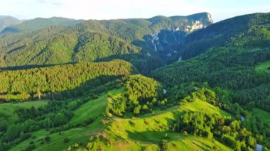 View from high rock to old village town Smolyan with green meadows for cattle walking and houses, between mountain range of Rhodope Mountains sheltered by spruce forests. UHD 4K video realtime