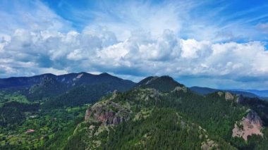 View from high rock to old village town Smolyan with green meadows for cattle walking and houses, between mountain range of Rhodope Mountains sheltered by spruce forests. UHD 4K video realtime