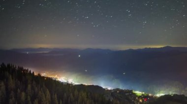 Night intermountain city of Smolyan with bright evening electric lights under a clear sky with bright small stars. UHD 4K video timelaps