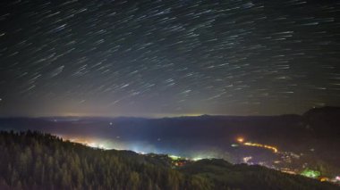 Night intermountain city of Smolyan with bright evening electric lights under a clear sky with bright small stars. UHD 8K video timelaps