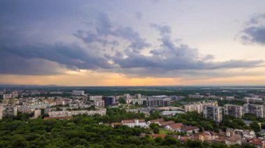 Ancient intermountain town Plovdiv with old residential houses and green fields, against backdrop of Rhodope Mountains and hills covered with spruce forests and sky. UHD 4K video timelaps