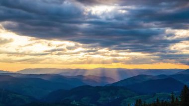 Cloudy weather over low hills covered with spruce evergreen forests in Rhodope Mountains against backdrop of sunset sky, and mystical thick white fog between mountain ranges. UHD 4K video timelaps