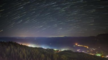 Night intermountain city of Smolyan with bright evening electric lights under a clear sky with bright small stars. UHD 4K video timelaps