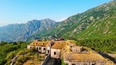 Karadağ dağlarının tepesindeki tarihi kale, sahil beldesi turizm beldelerinin arka planına ve açık mavi bir gündüz gökyüzüne karşı. UHD Video gerçek zamanlı 4K