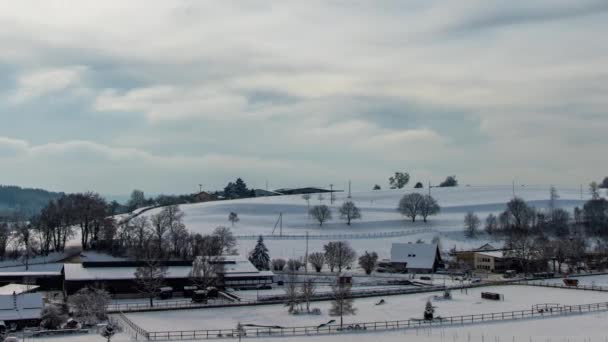 雪は古い小さな村を覆い 冬の曇りの天候では木の葉が茂った丘陵地帯に木造家屋や農業農場があった ビデオ Uhdタイムラプス — ストック動画