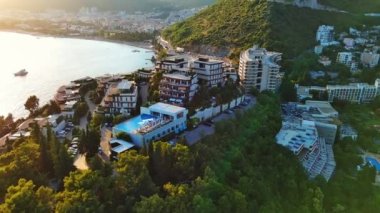 Lüks tatil beldesi Dukley, masmavi sığ Adriyatik Denizi yakınlarındaki yeşil bahçeler ve kumlu plajlar Budva ve Becici kıyı kentlerinin arka planına karşı. UHD Video gerçek zamanlı 4K
