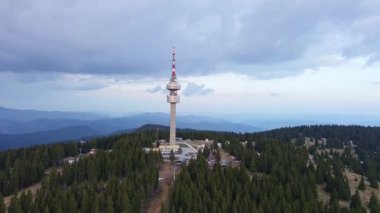 Snezhana 'nın dağlık tepesindeki yüksek turist gözlem kulesi Rodop dağları ve tepelerindeki yeşil ladin yoğun ormanlarıyla kaplıydı. UHD 4K video gerçek zamanlı