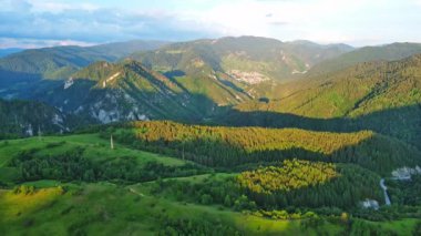 View from high rock to old village town Smolyan with green meadows for cattle walking and houses, between mountain range of Rhodope Mountains sheltered by spruce forests. UHD 4K video realtime