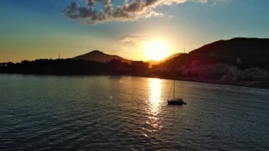 Budva ve Becici tatil beldeleri, sakin Adriyatik Denizi yakınlarında lüks oteller ve rahat plajlarla Karadağ Dağları ve mavi gökyüzüne karşı. UHD Video gerçek zamanlı 4K
