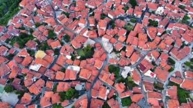 Small Greek quiet resort town of Litochoro with small houses with red tiled roofs, narrow empty streets and fresh green bright vegetation