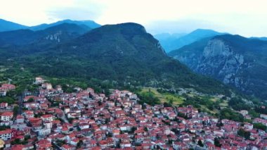 Küçük Yunan sakin kasabası Litochoro 'da kırmızı kiremit çatılı küçük evler ve dar sokaklar ile ünlü yüksek Olimpos Dağı ve bulutlu bir gökyüzü. UHD Video gerçek zamanlı 4K