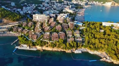 Lüks tatil beldesi Dukley, masmavi sığ Adriyatik Denizi yakınlarındaki yeşil bahçeler ve kumlu plajlar Budva ve Becici kıyı kentlerinin arka planına karşı. UHD Video gerçek zamanlı 4K