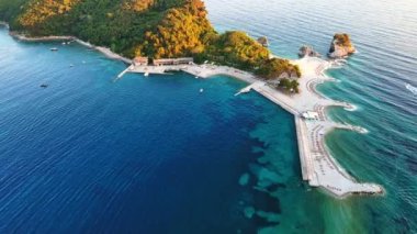Tarihsel antik turizm adası Aziz Niklas 'ta, açık arkaplan üzerindeki gök mavisi Adriyatik Denizi' nin kayalık kıyılarında bitki örtüsü ile. UHD Video gerçek zamanlı 4K