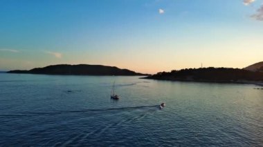 Budva ve Becici tatil beldeleri, sakin Adriyatik Denizi yakınlarında lüks oteller ve rahat plajlarla Karadağ Dağları ve mavi gökyüzüne karşı. UHD Video gerçek zamanlı 4K