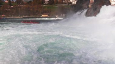 Turistler için büyük turist tekneleri, İsviçre 'deki eski kasabanın arka planına karşı bir sürü güzel beyaz nemli püskürtüyle ünlü Ren Şelalesi' nin yanında yüzüyor. 4k video yavaş çekim UHD