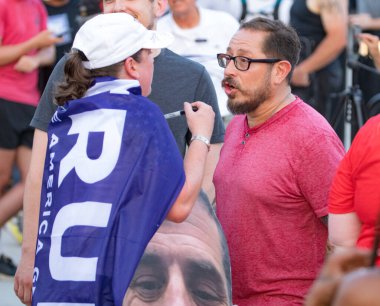 Milwaukee, Wisconsin, USA - August 23, 2023: Supporters of former President Donald Trump argue with counter-protesters at the first 2024 Republican Presidential Debate. clipart