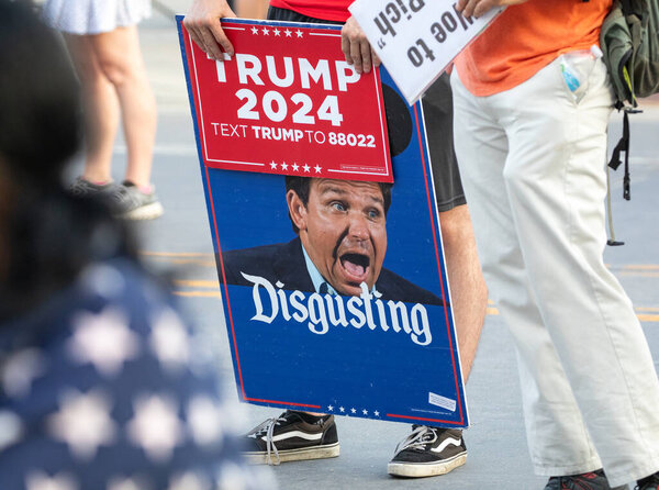 Milwaukee, Wisconsin, USA - August 23, 2023: A supporter of President Joe Biden holds a protest sign against Florida Governor Ron Desantis at the entrance to the first 2024 Republican Presidential Debate.