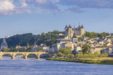 Fransa 'nın Saumur kasabası, Loire nehrinin kenarında gün boyunca bulutların altında yer alır..