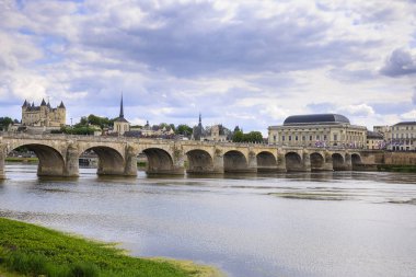 Fransa 'nın Saumur kasabası, Loire nehrinin kenarında gün boyunca bulutların altında yer alır..