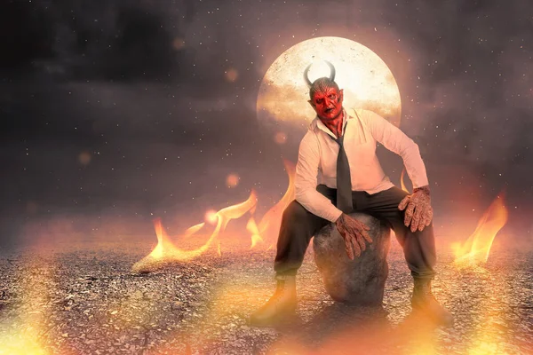 魔鬼人坐在火和满月的背景下 万圣节的概念 — 图库照片