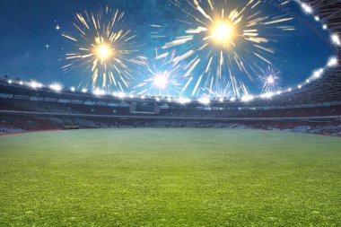 Futbol stadyumunun içinde havai fişek arka planında çimenler