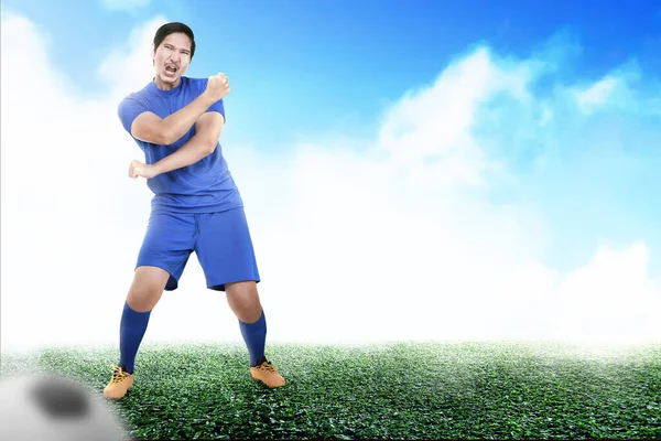 身穿蓝色球衣的亚洲足球运动员在足球场庆祝胜利 — 图库照片
