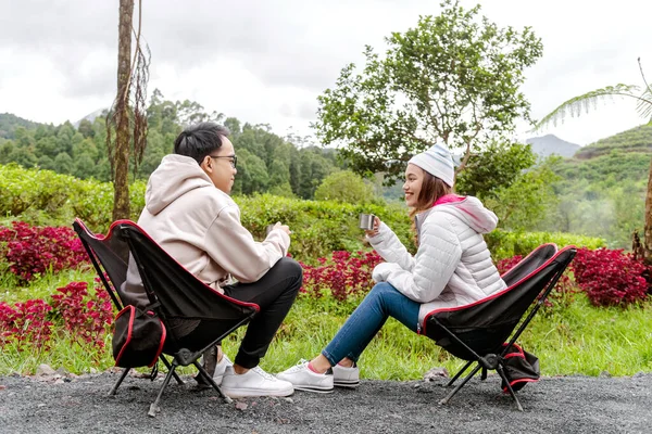 Asyalı Çift Sıcak Bir Şeyler Içerken Oturmuş Doğada Kamp Faaliyetlerinin — Stok fotoğraf