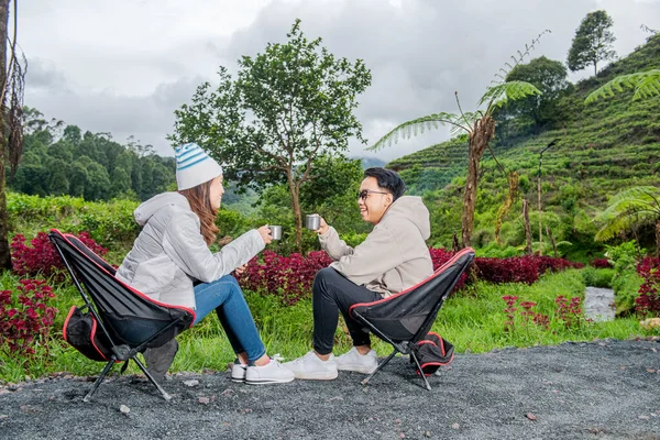Asian Couple Sitting While Holding Hot Drink Enjoying Camp Activity — Stock Photo, Image