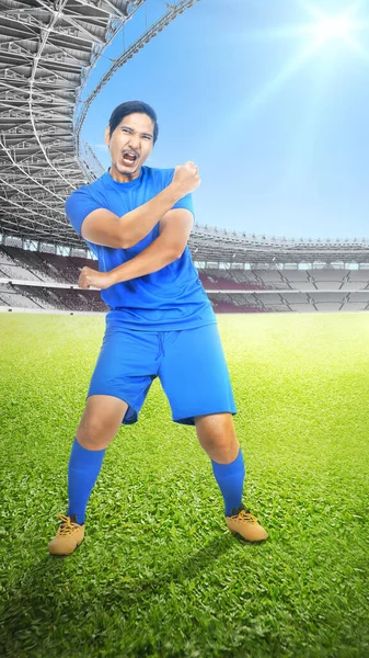 身穿蓝色球衣的亚洲足球运动员在足球场庆祝胜利 — 图库照片