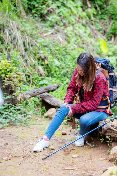 亚洲女人头戴帽子 背着背包 背着手杖 坐在森林里休息 — 图库照片